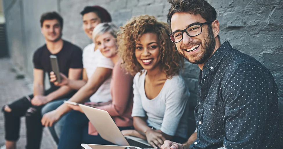 Grupo de jovens profissionais sorrindo com notebook